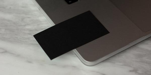 Fekete egsedi névjegykártya egy MacBookon.